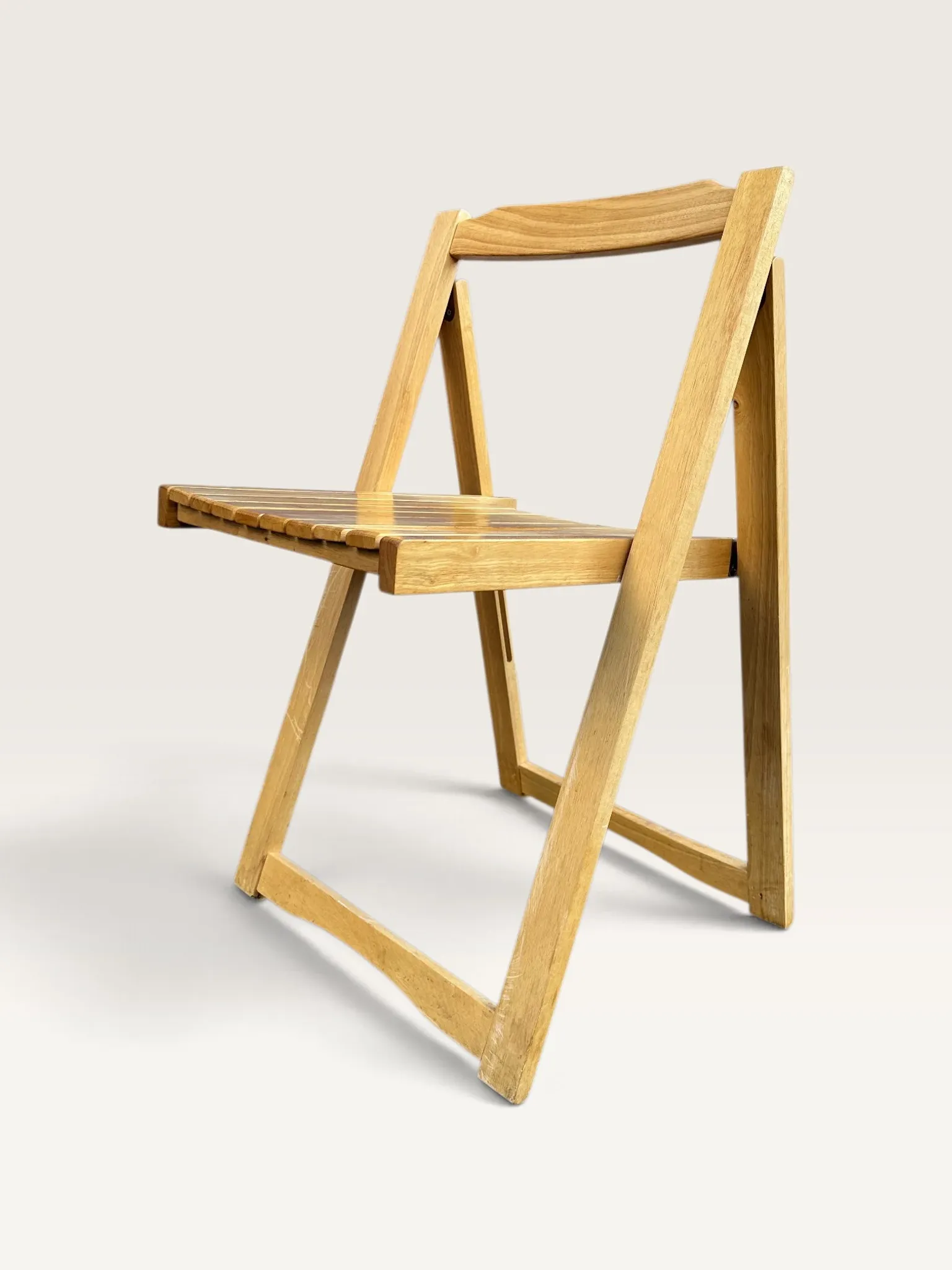 Blonde wooden folding chair in the style of Aldo Jacober.