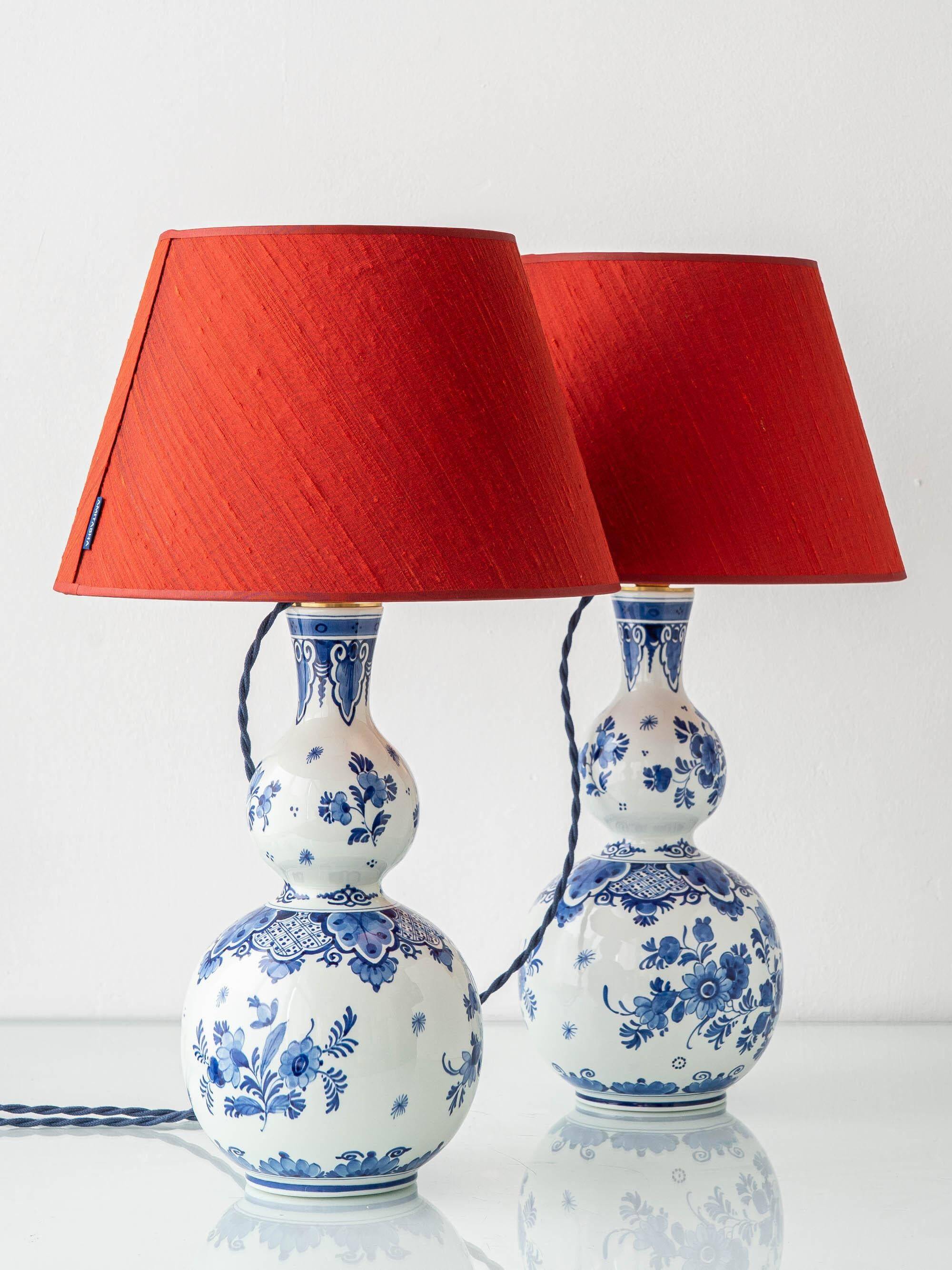 Pair of Royal Delft blue and white ceramic table lamps with new vermilion silk shades.