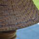 Large wooden lamp with a woven rattan shade.