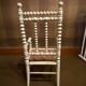 Antique wooden child's chair with turned legs and caning, white patina.