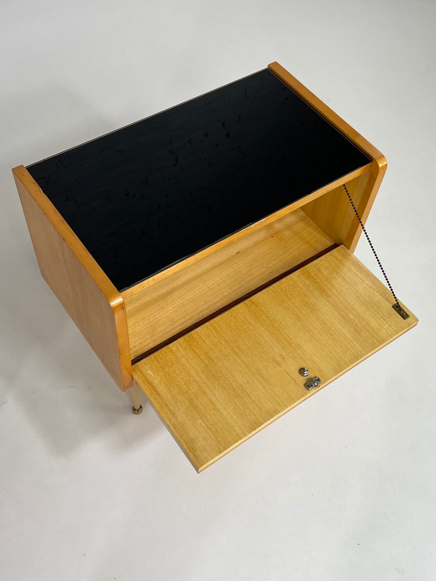 Pair of bedside tables in wood, brass and black glass top