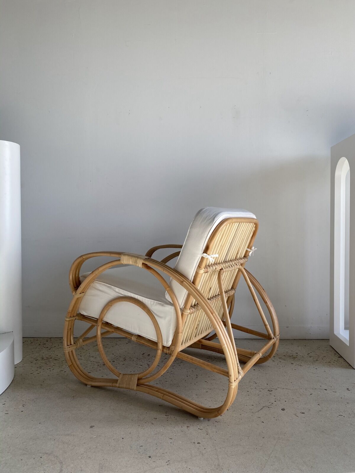 Large rattan rest chair and white cushions