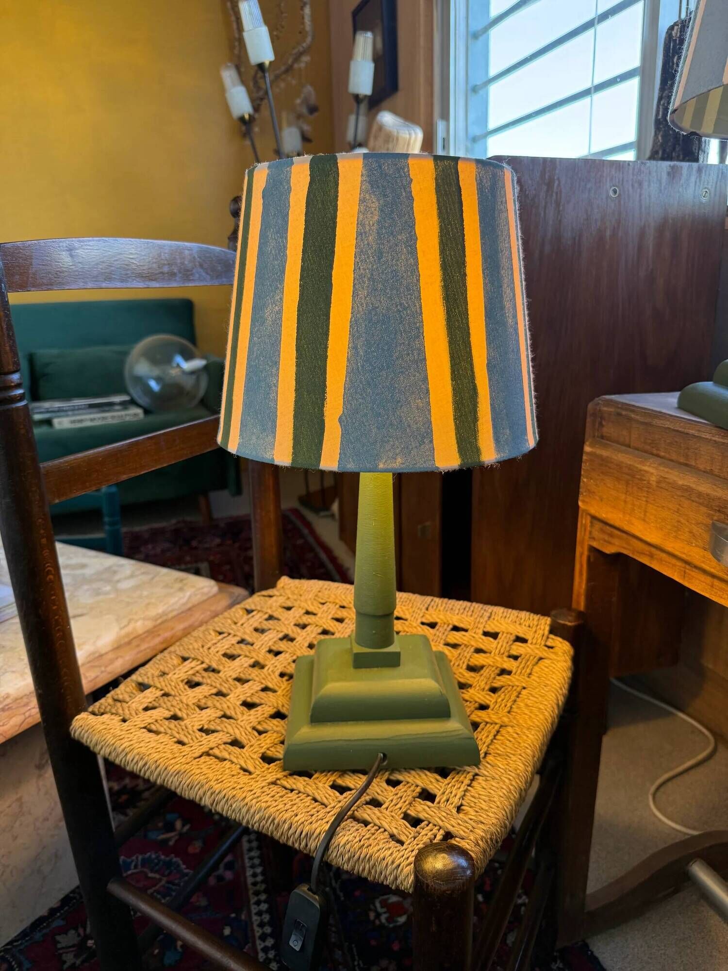 Pair of vintage wooden lamps with their striped beige, blue, and green shades.