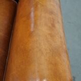 Fauteuil ancien en cuir de mouton couleur cognac