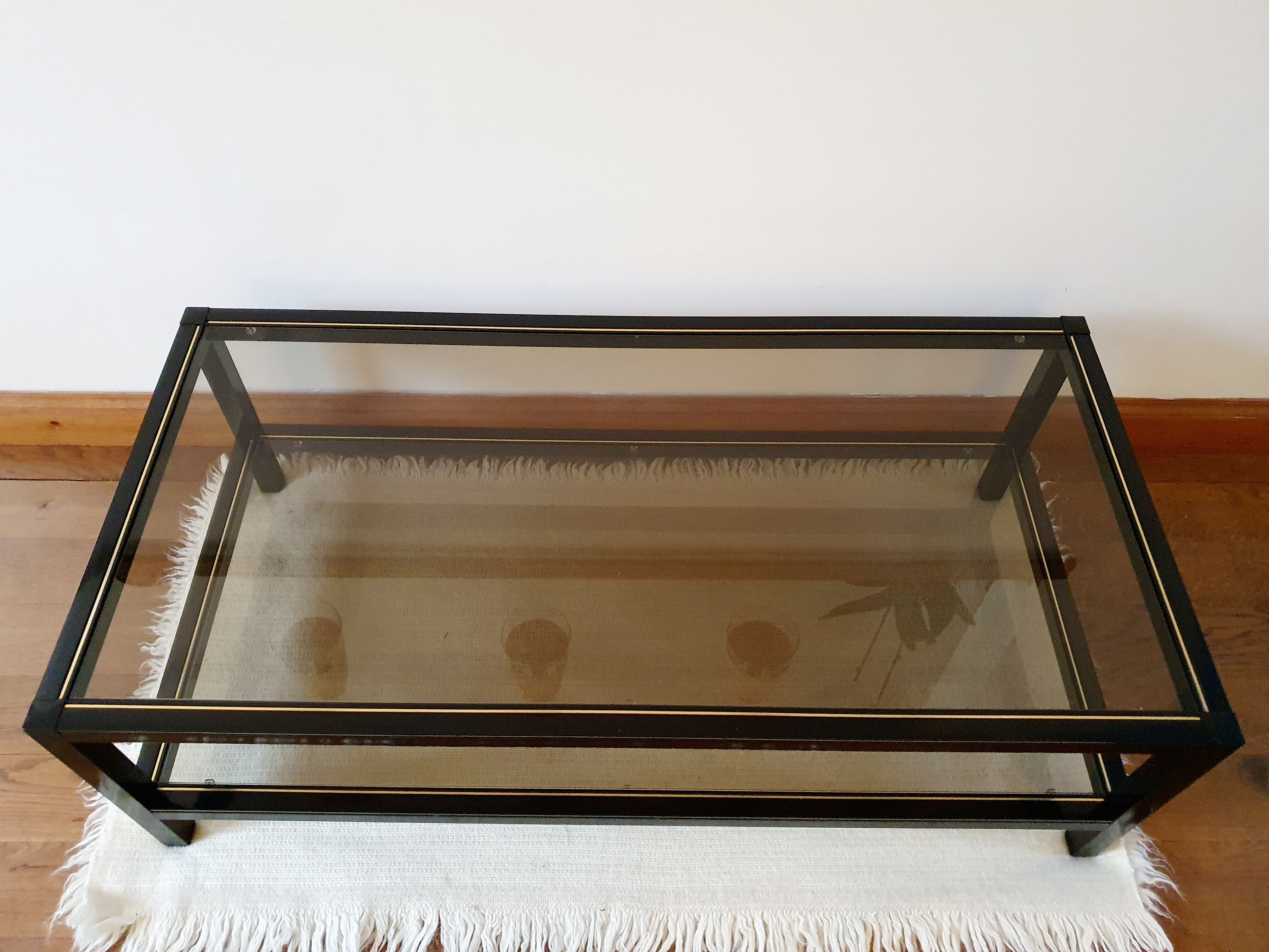 Black and gold coffee table with a double smoked glass top