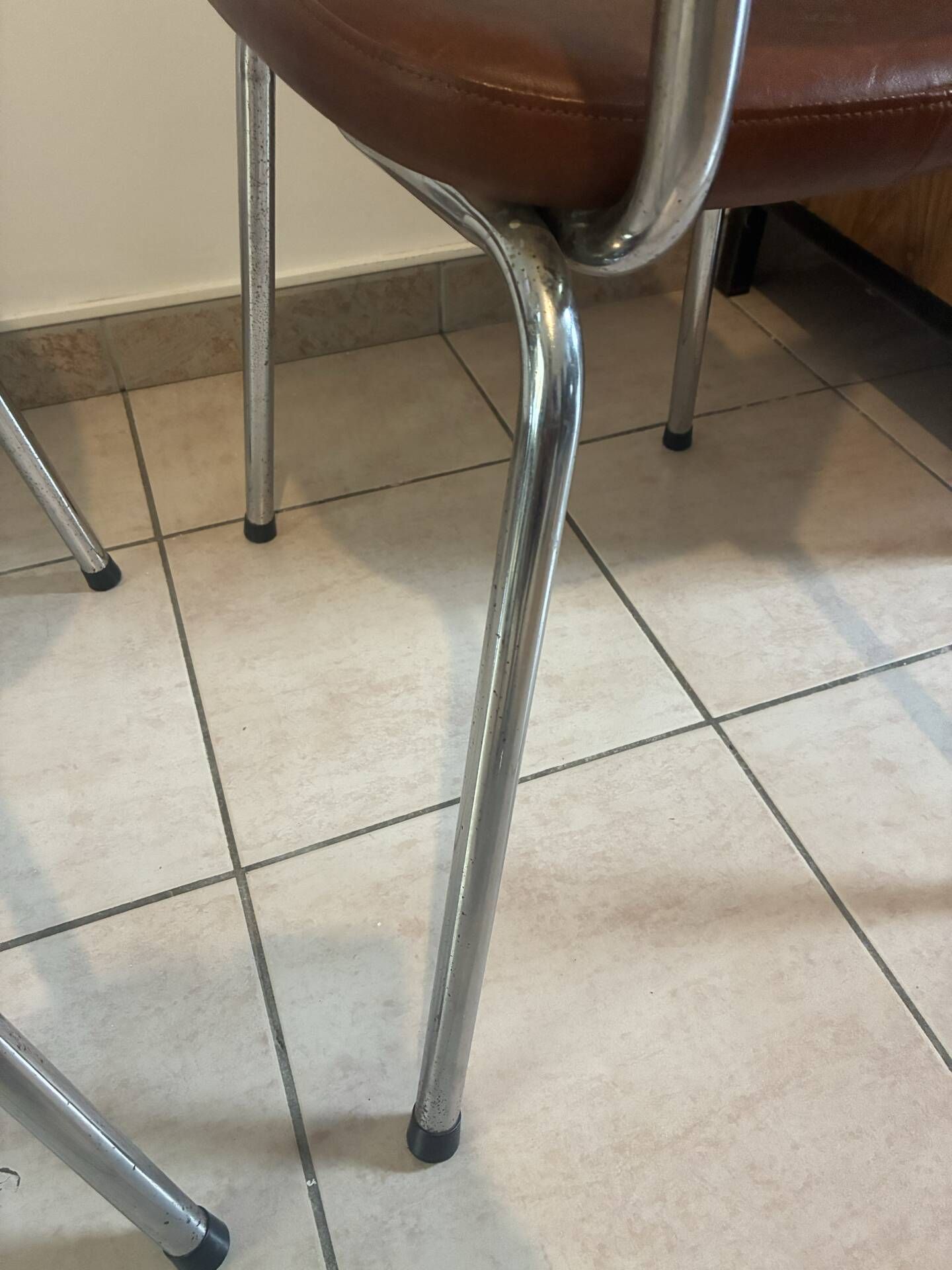 Two brown faux leather chairs.