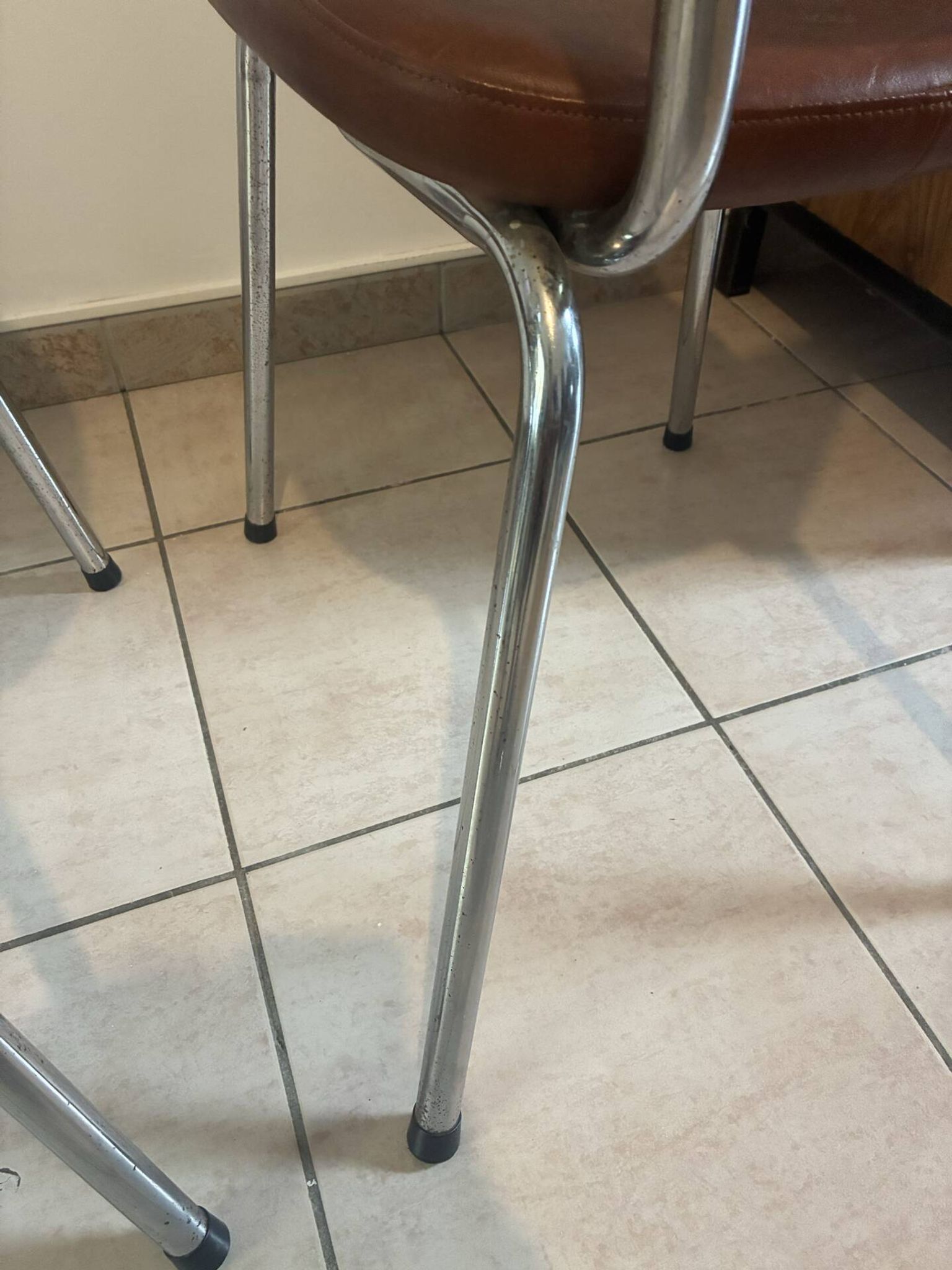 Two brown faux leather chairs.