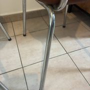 Two brown faux leather chairs.