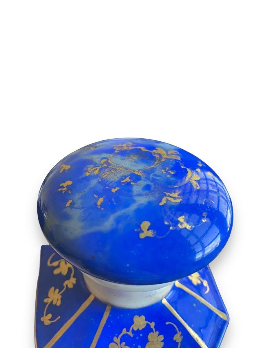 Perfume bottle in porcelain of old paris blue background