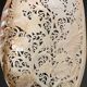 Perforated shell hand-decorated on a wooden base