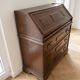 Antique wooden secretary with a drop-down front and drawers.
