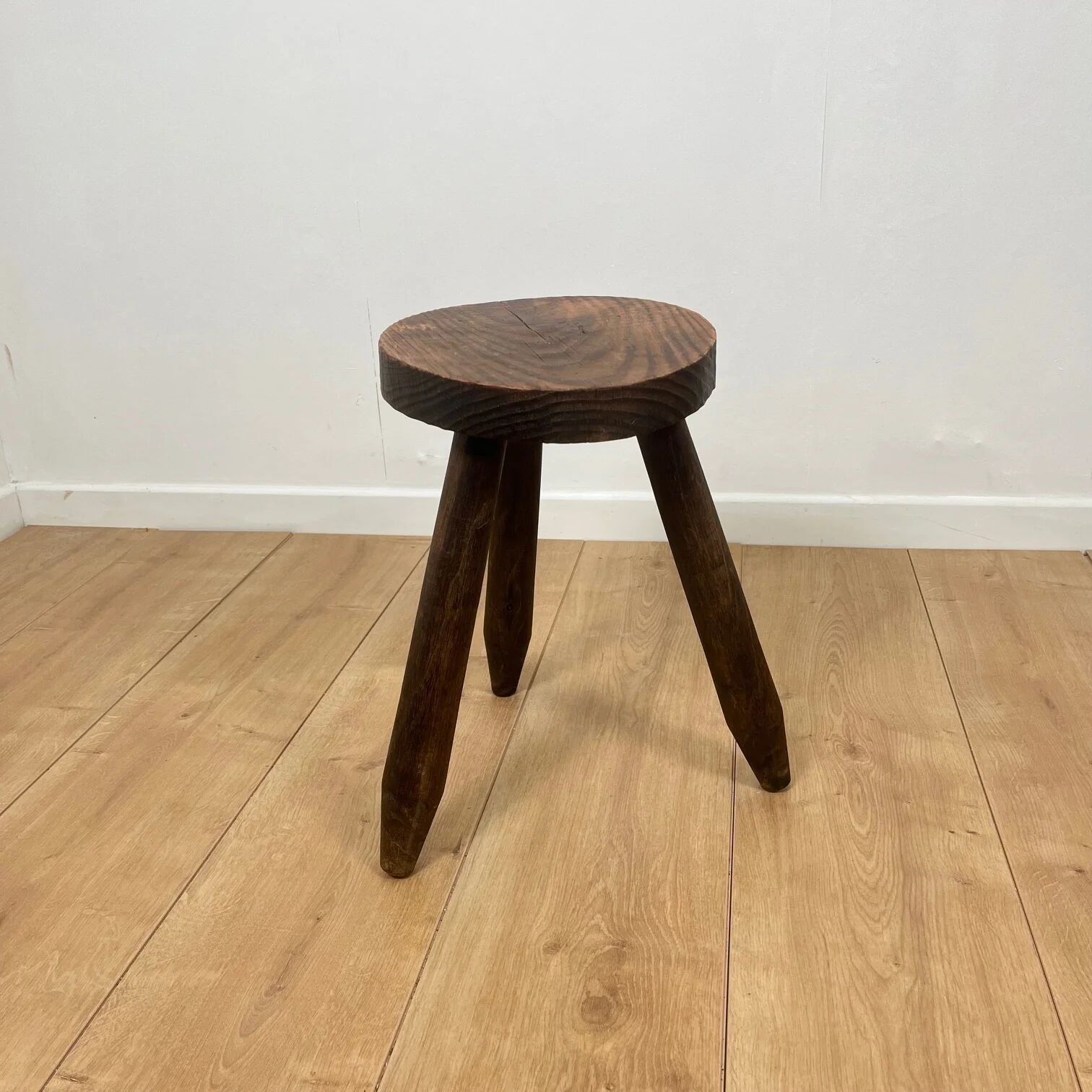 Petit tabouret tripode brutaliste en bois massif