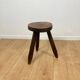 Small brutalist tripod stool in solid wood.