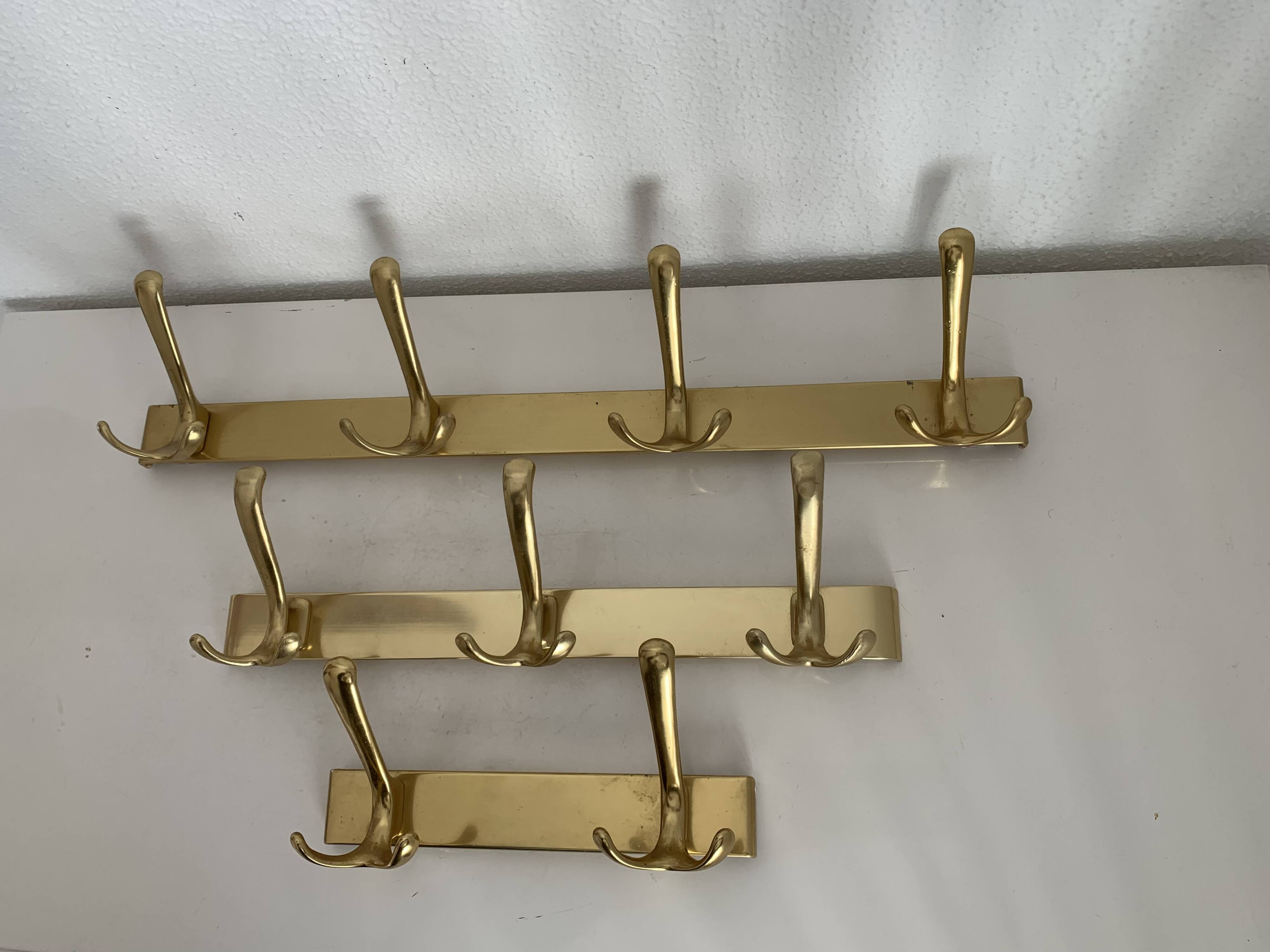 Three vintage 1960s gold coat racks with 4, 3 and 2 hooks