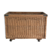 Old large wicker laundry basket on wheels
