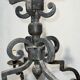 Two-tiered wrought iron chandelier with eight light arms in Gothic style.