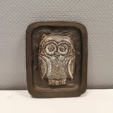 Small relief with a motif of an owl emerging from the back plate.