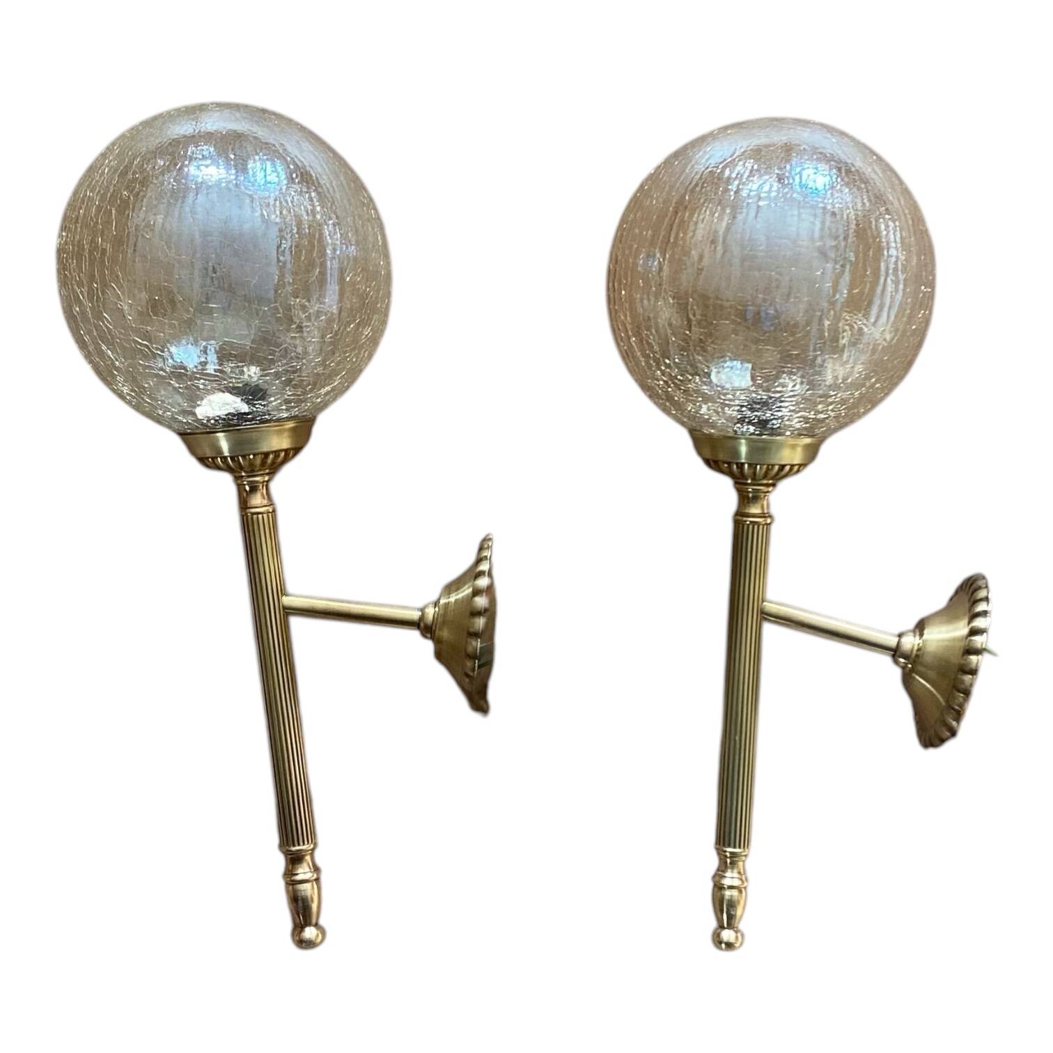 Pair of antique wall sconces torch style brass with glass globes in gold.