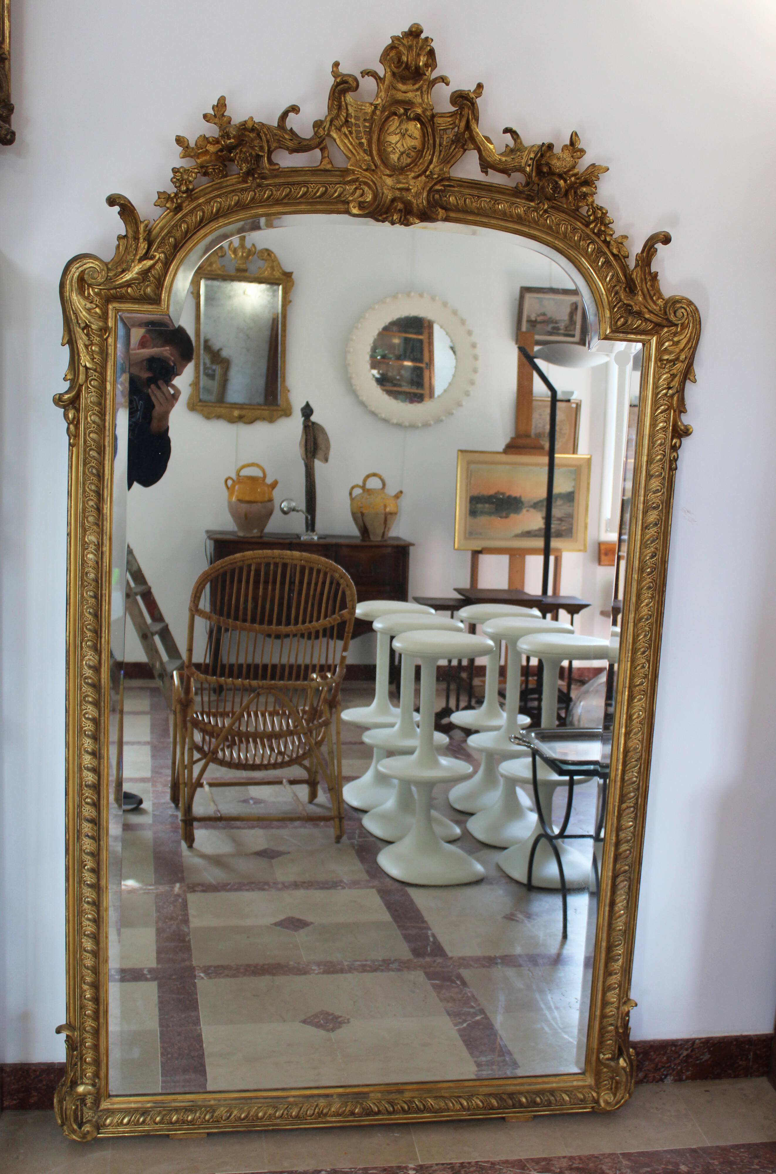 Large 19th-century wooden and gilt-studded mirror decorated with a cornucopia motif.