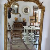 Large 19th-century wooden and gilt-studded mirror decorated with a cornucopia motif.