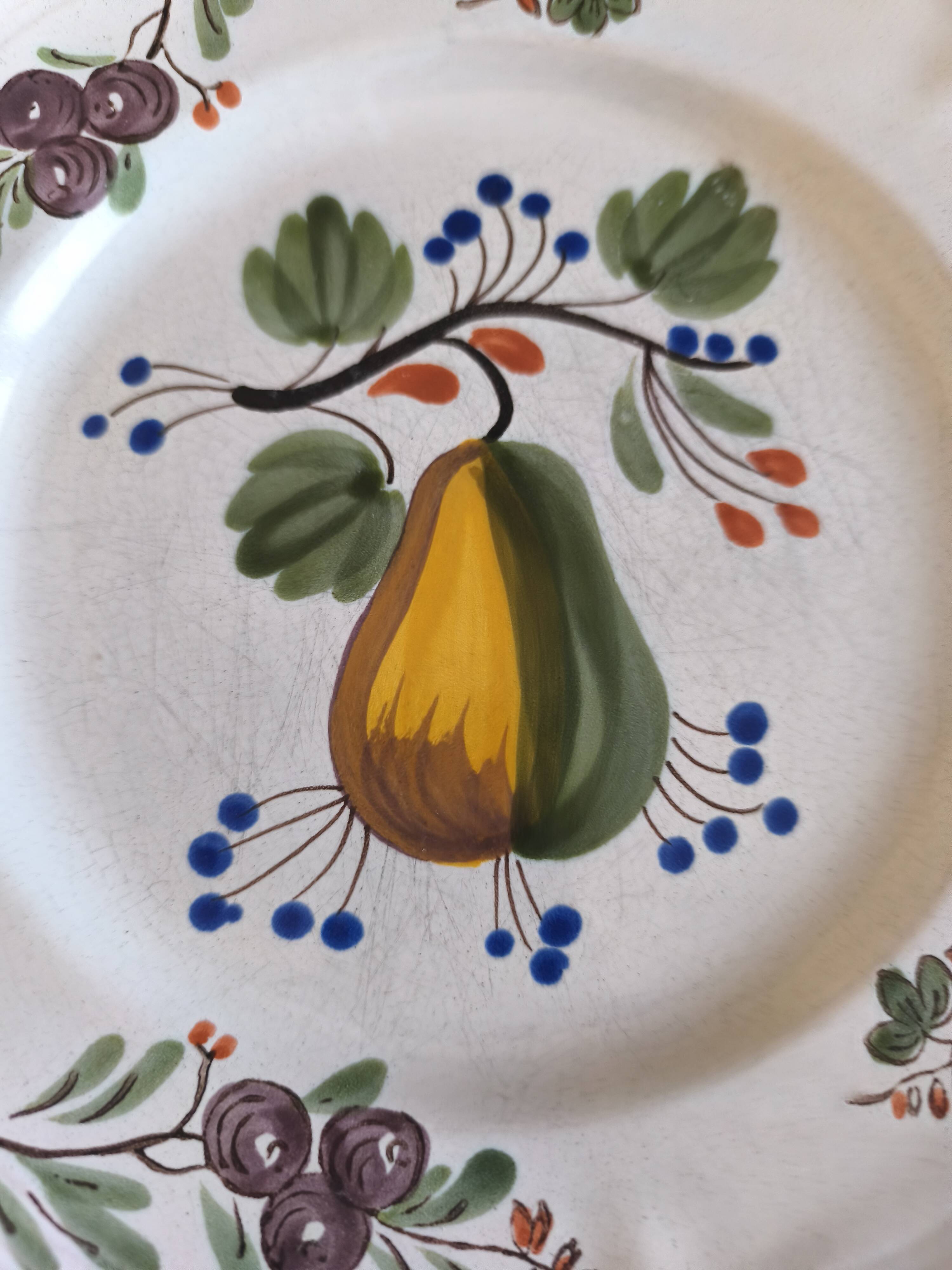 Two earthenware plates with fruits, pears and plums.