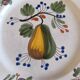 Two earthenware plates with fruits, pears and plums.