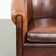 Sheepskin club armchair with deep warm colours and black piping
