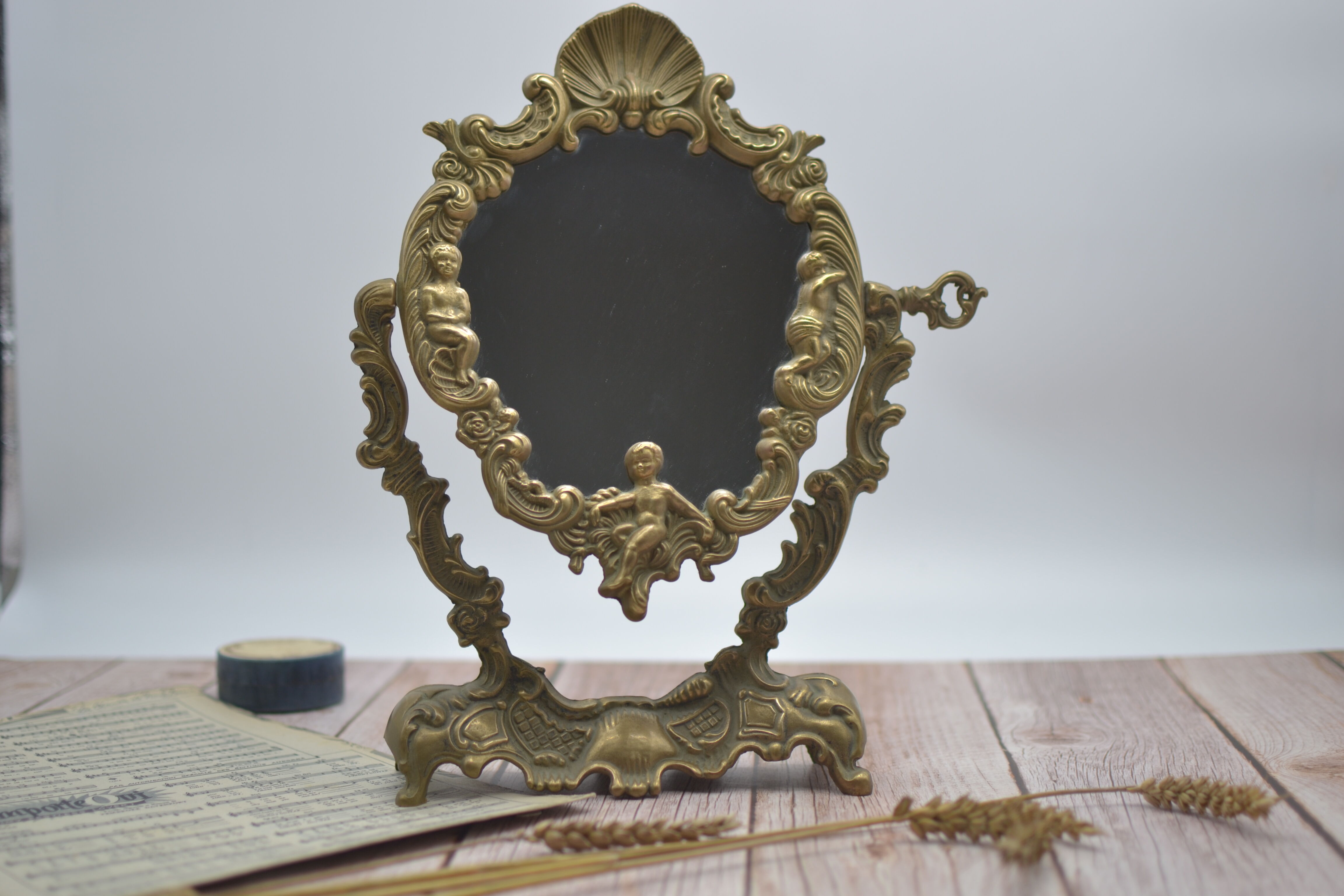 Adjustable psyche mirror of 33 centimeters in gilded bronze with angel ornament