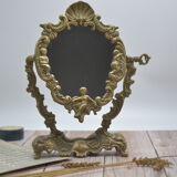 Adjustable psyche mirror of 33 centimeters in gilded bronze with angel ornament