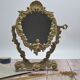Adjustable psyche mirror of 33 centimeters in gilded bronze with angel ornament