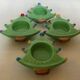 Four Christmas tree-shaped candle holders