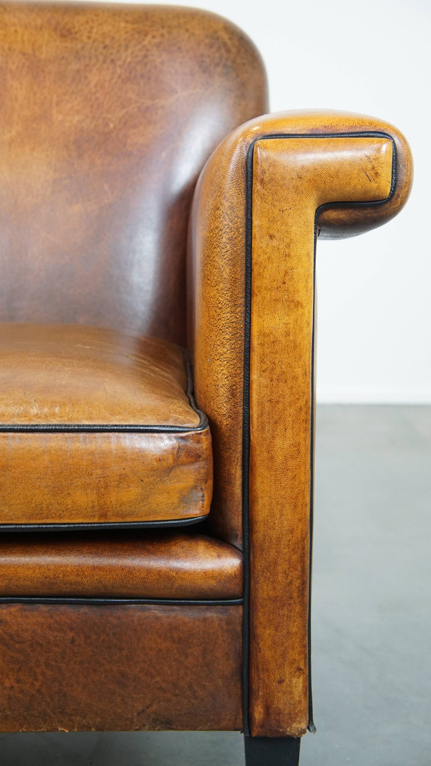 Sheepskin Art Deco design armchair with sleek finish and black piping