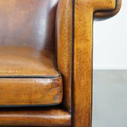 Sheepskin Art Deco design armchair with sleek finish and black piping