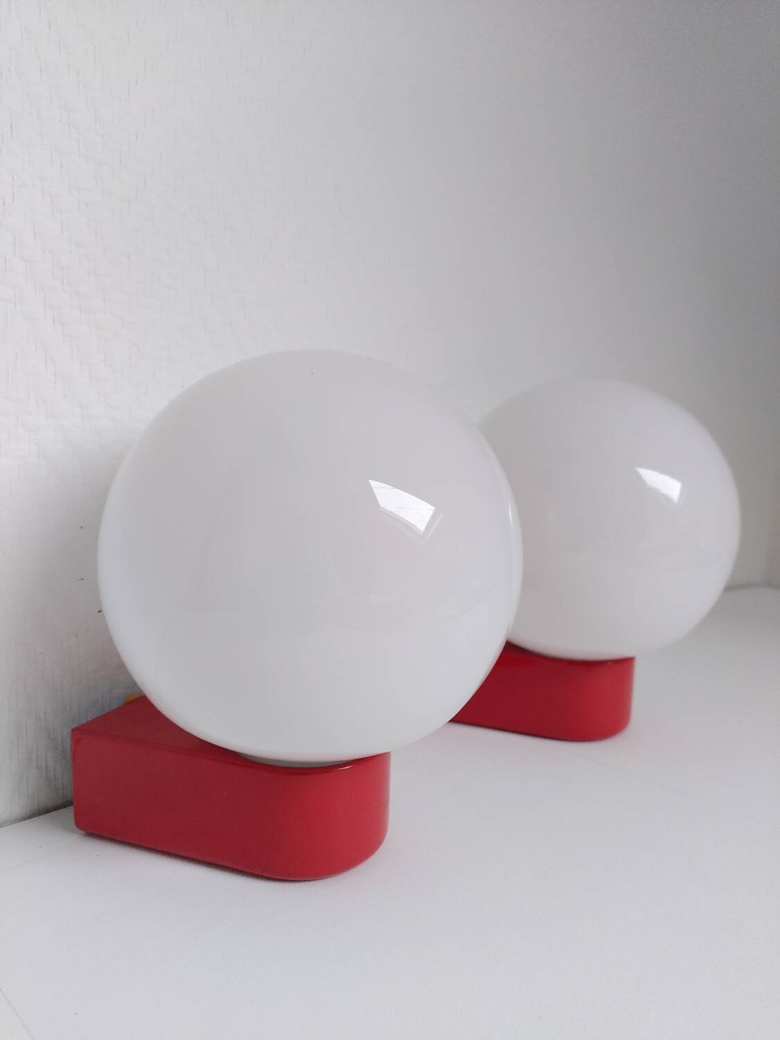 2 postmodern opaline and red metal wall lights, 1980