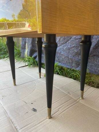 Vintage wooden bedside table from the 50s-60s with black tapered legs and brass tips.