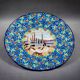 Longwy plate with polychrome enamels, decorated with the "City of Iron" motif.