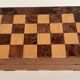 Old wooden chess set with a folding wooden box.
