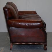 Restored Victorian sofa in leather with claw feet and feather cushions.