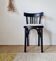 Curved black wooden bistro chair with striped seat