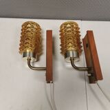 A set of wall lamps in teak wood, with amber colored glass