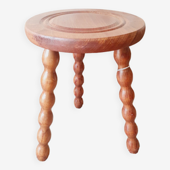 Wooden tripod stool with circle pattern on the seat