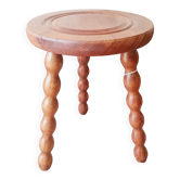 Wooden tripod stool with circle pattern on the seat