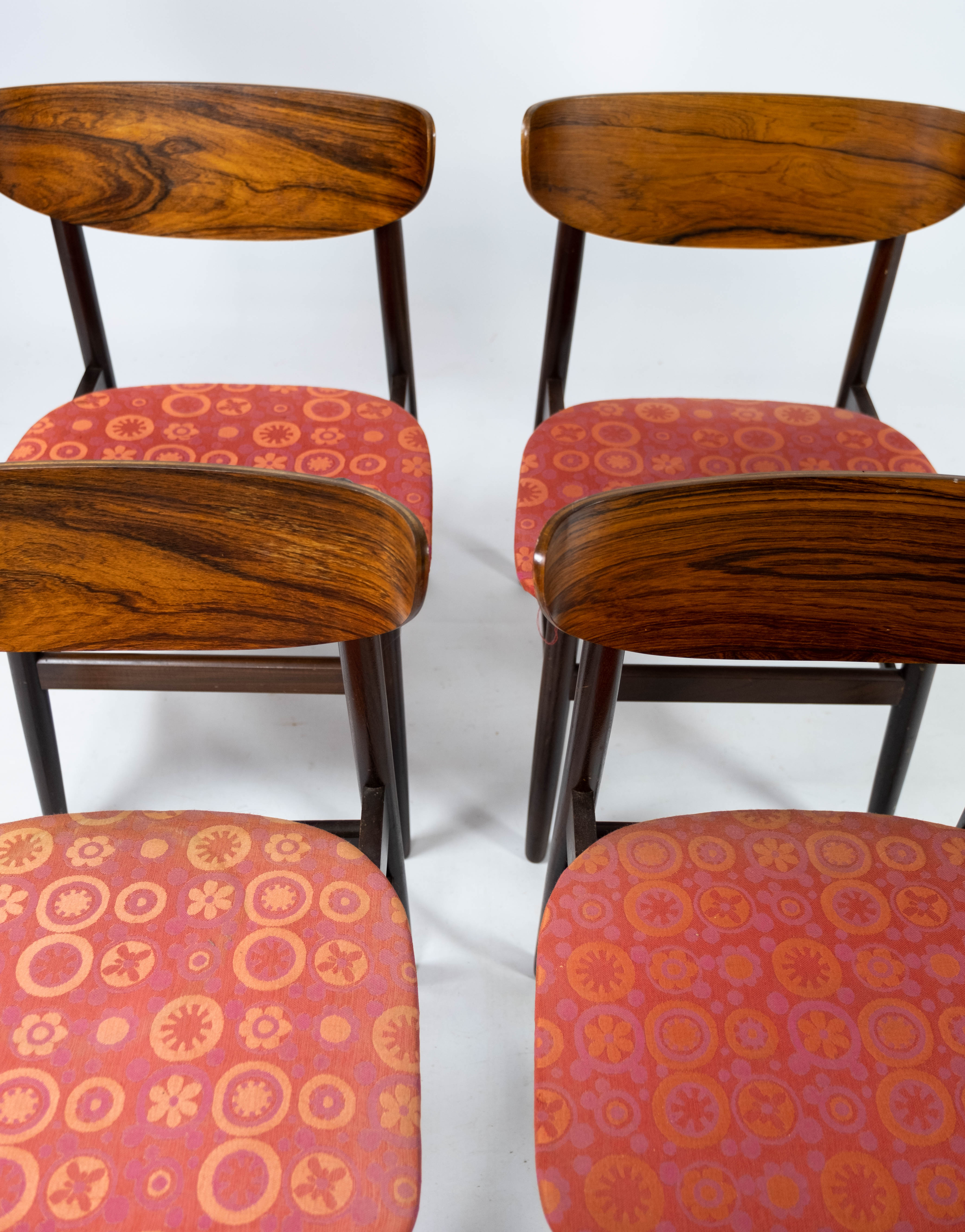 Set of four dining room chairs in rosewood and upholstered with red fabric, of danish design, 1960s