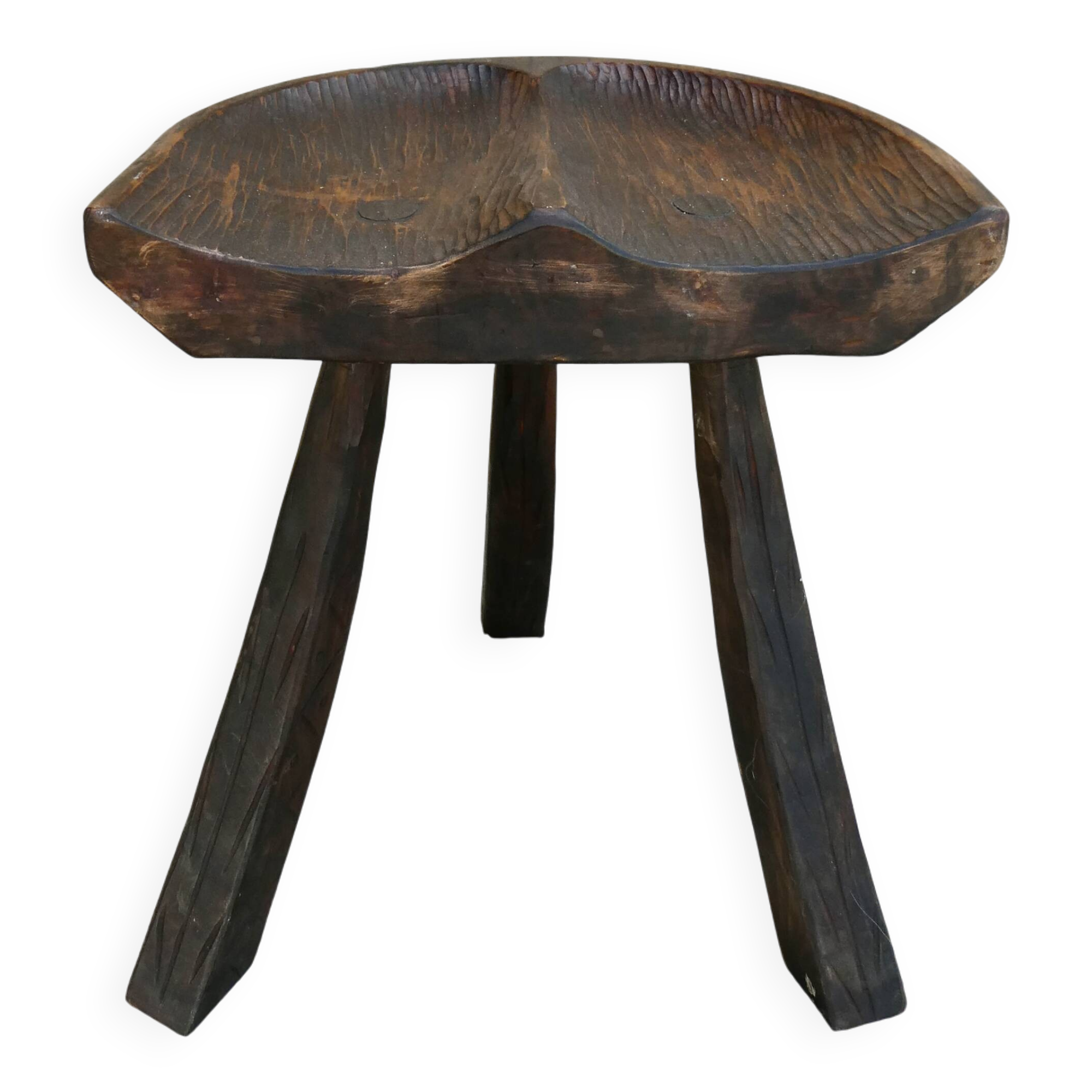 Tripod stool made of solid wood, with a carved seat.