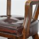Set of two brown leather Chesterfield dining chairs in English style.
