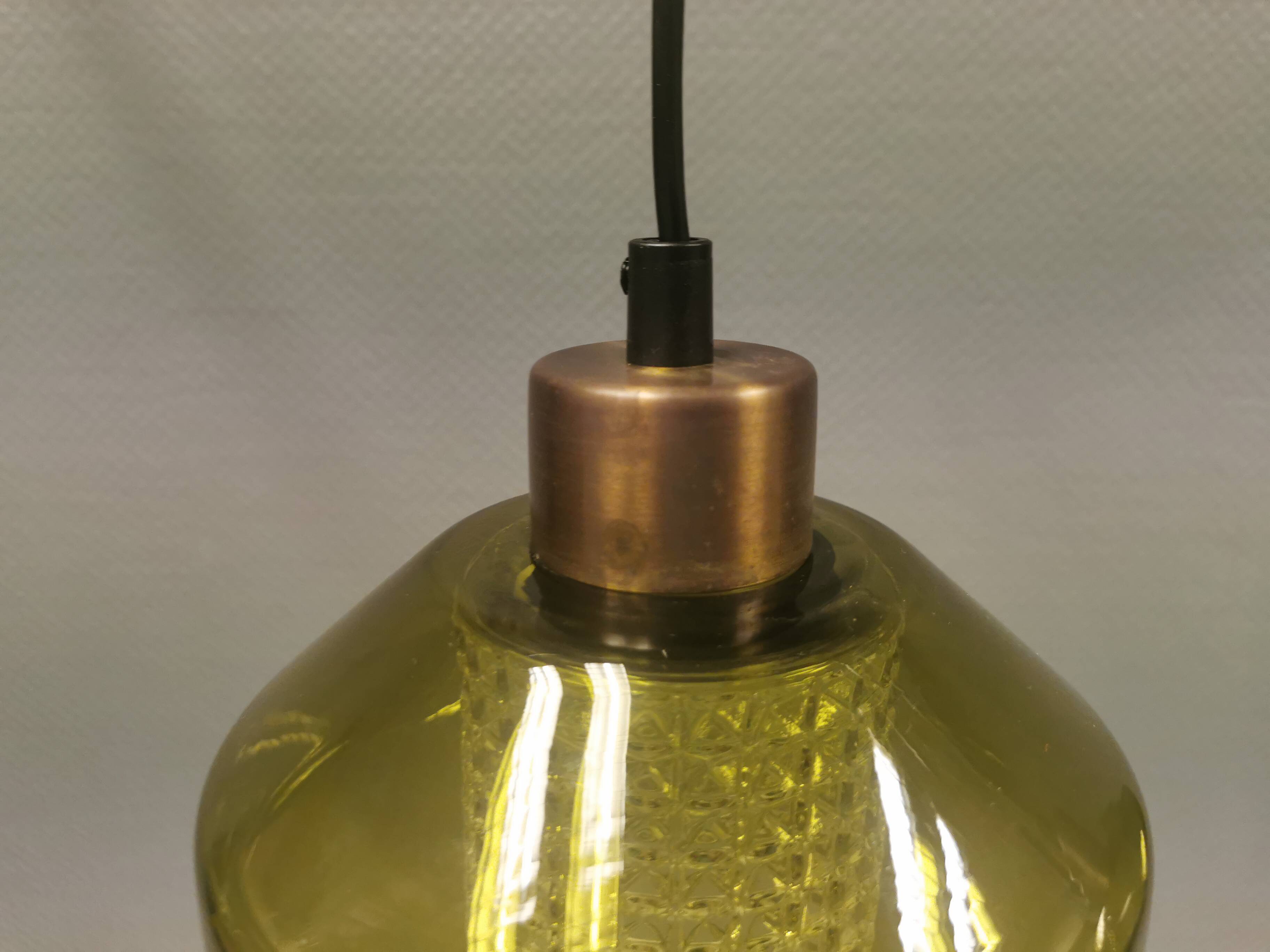 Hanging lamp with an outer shade of olive green glass and an inner shade of clear, crystal glass.