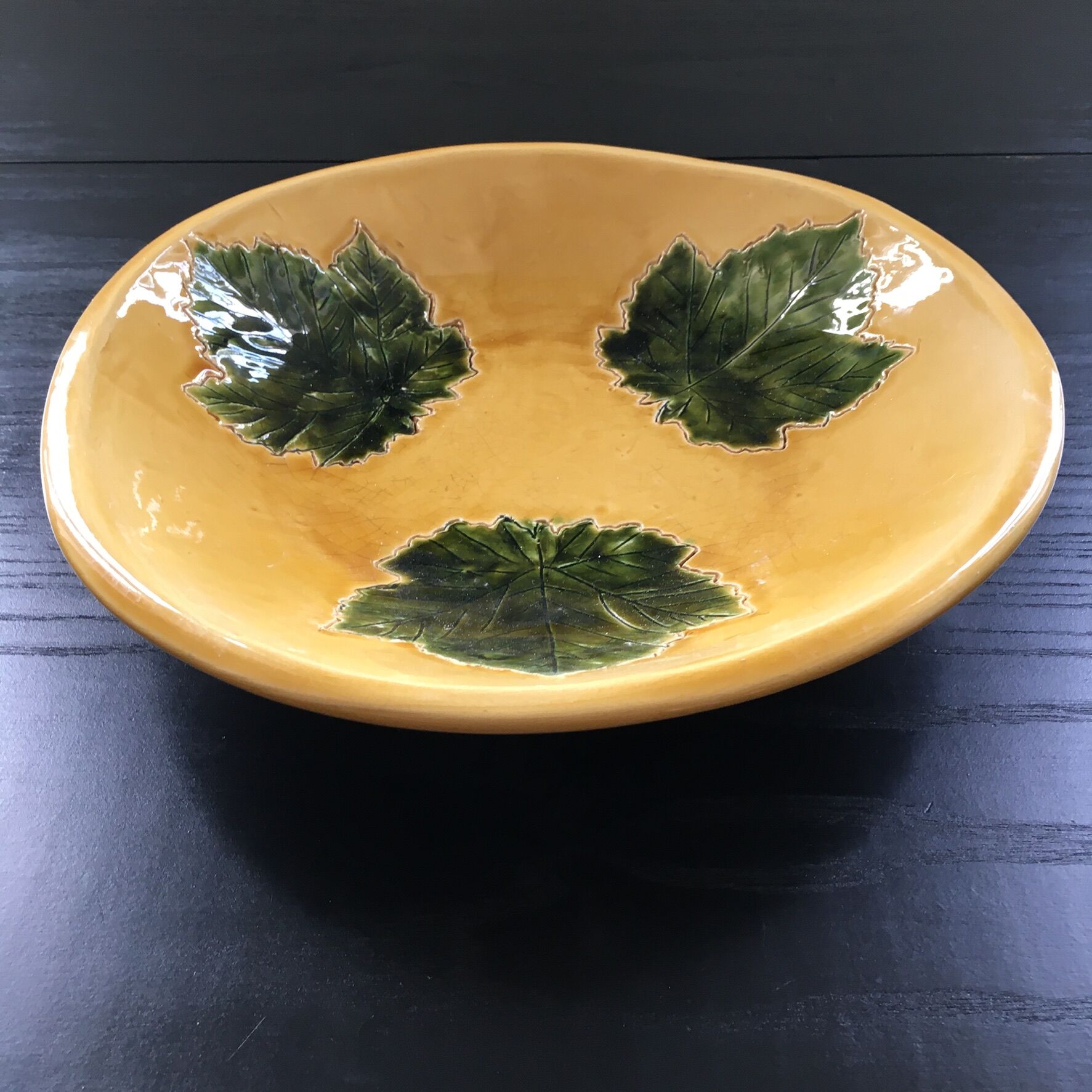 Plate signed with green leaf decoration.