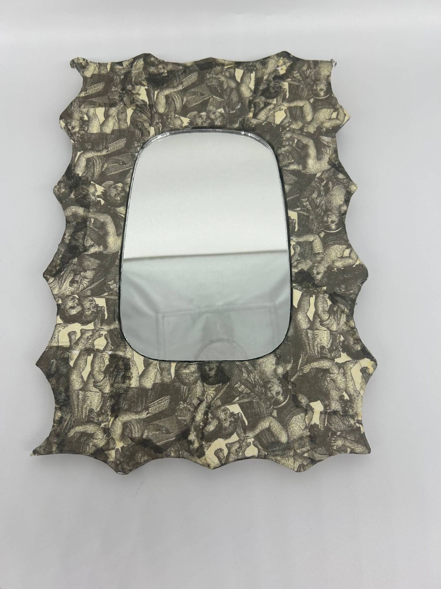 Free-form mirror decorated with cherubs.