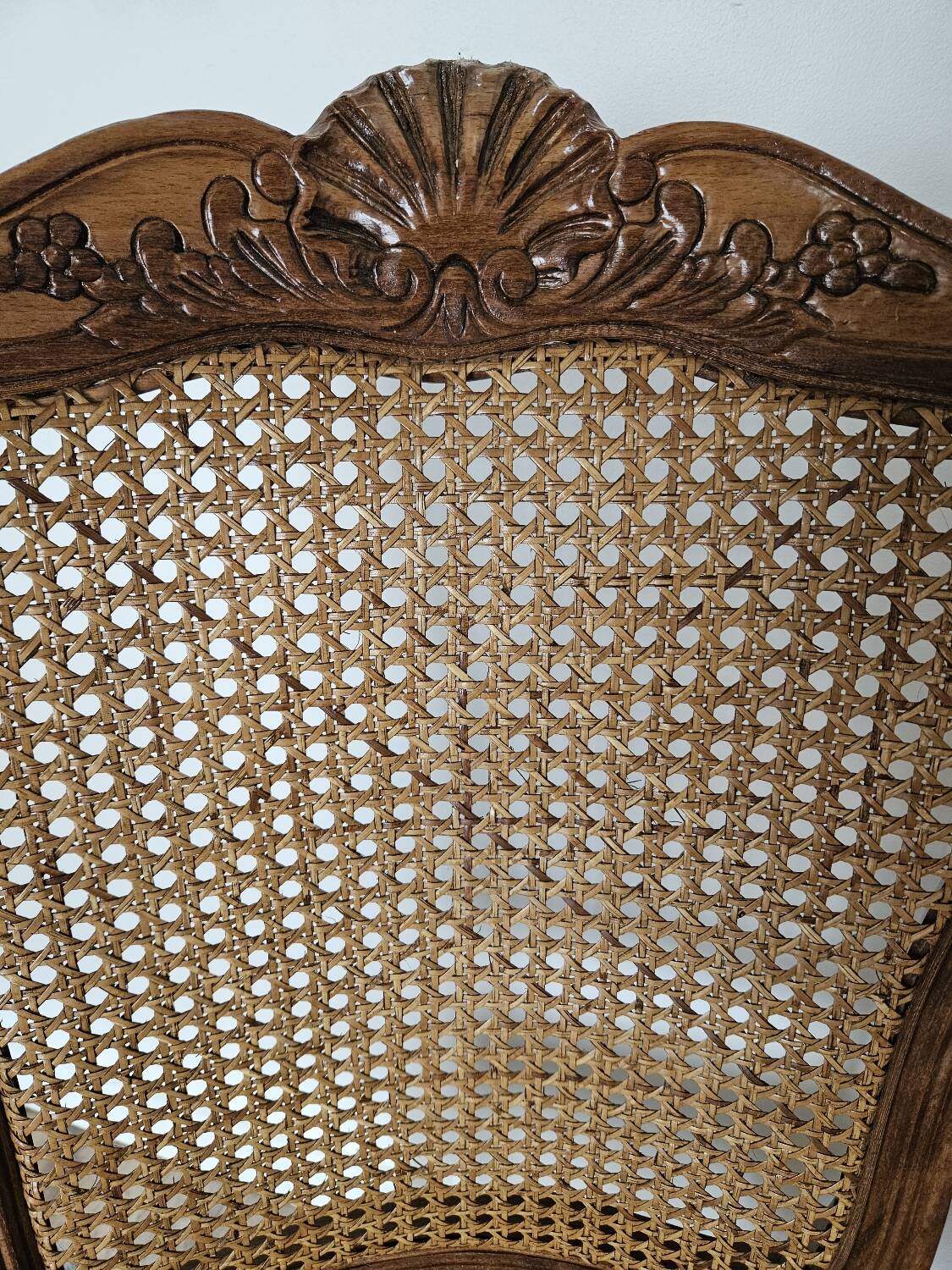 Détail de dossier en bois d'une chaise style Louis XV avec cannage en osier