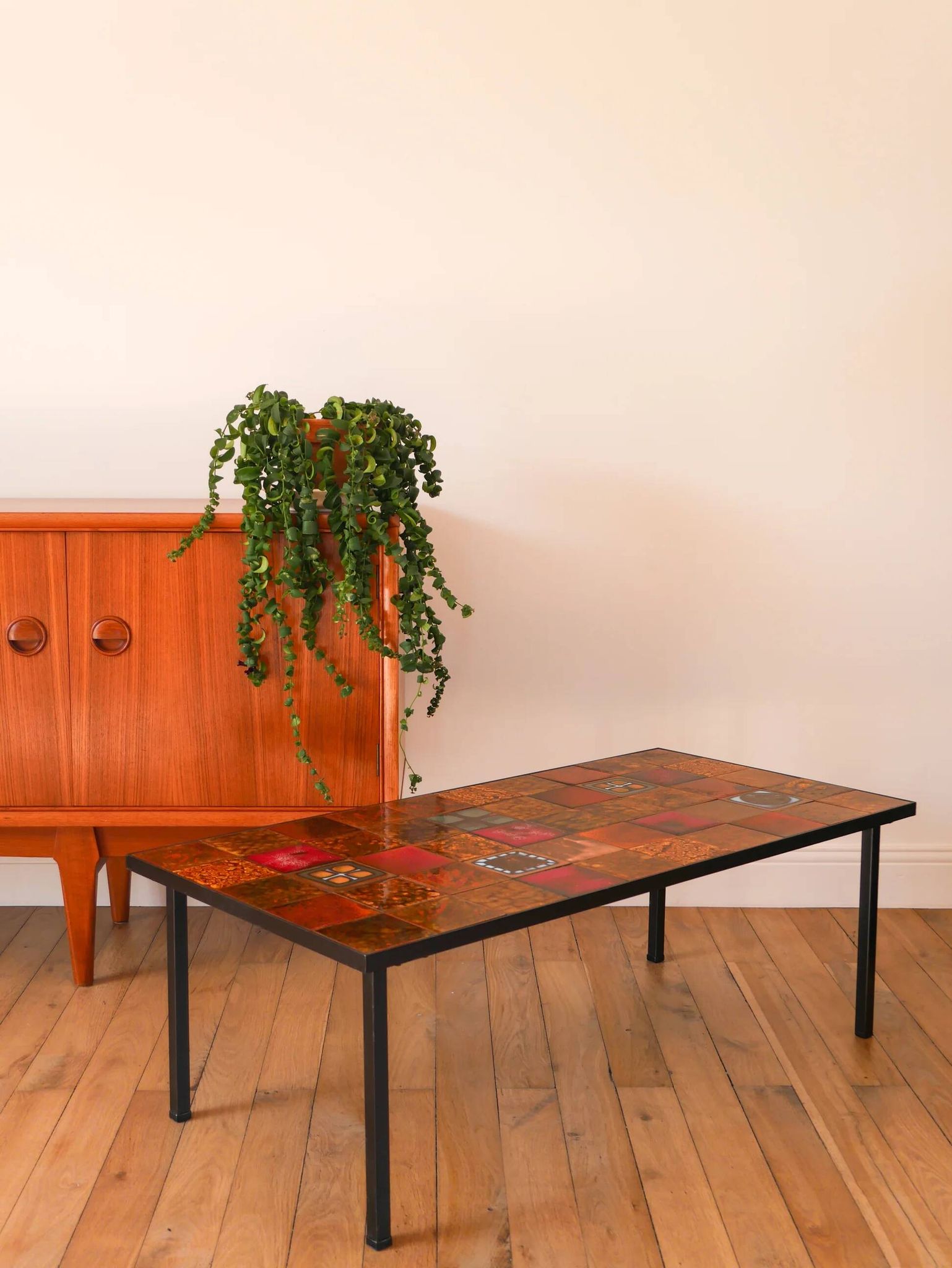 Ceramic and black iron coffee table, attributed to the Roche-Bobois brand, with a black metal base and structure, rectangular ceramic top from Vallauris with colourful patterns in ochre and orange, design from the 1970s.
